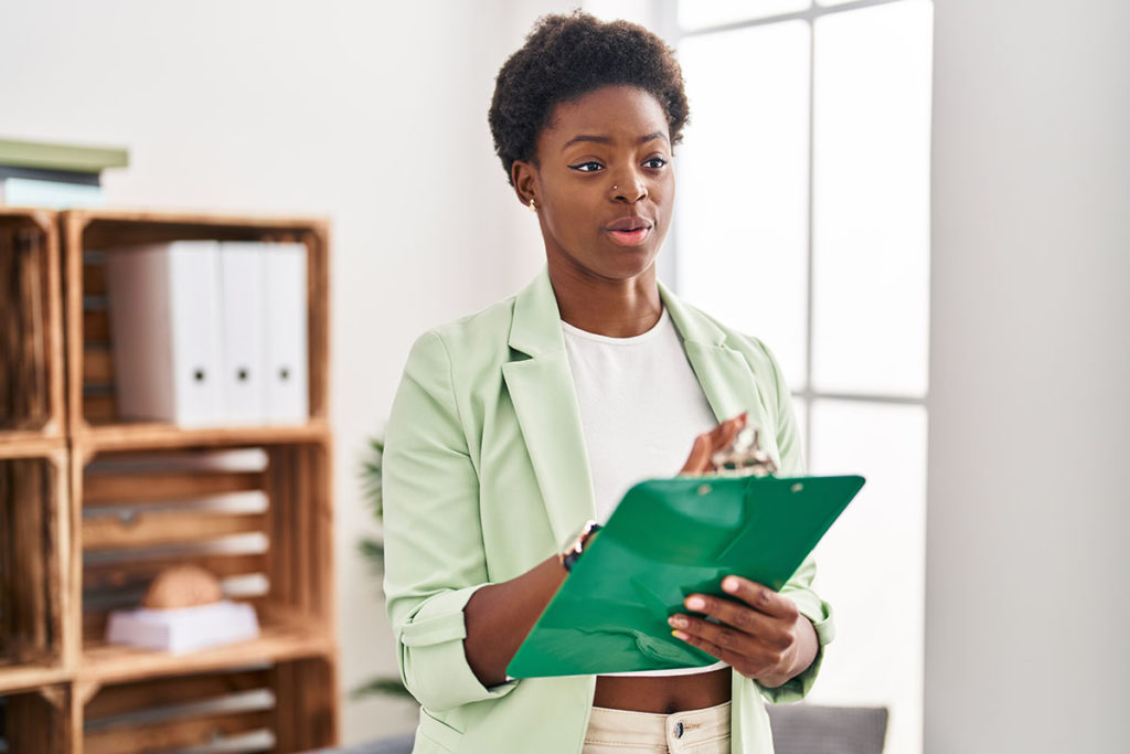 Woman with green folder discussing the benefits of cbt