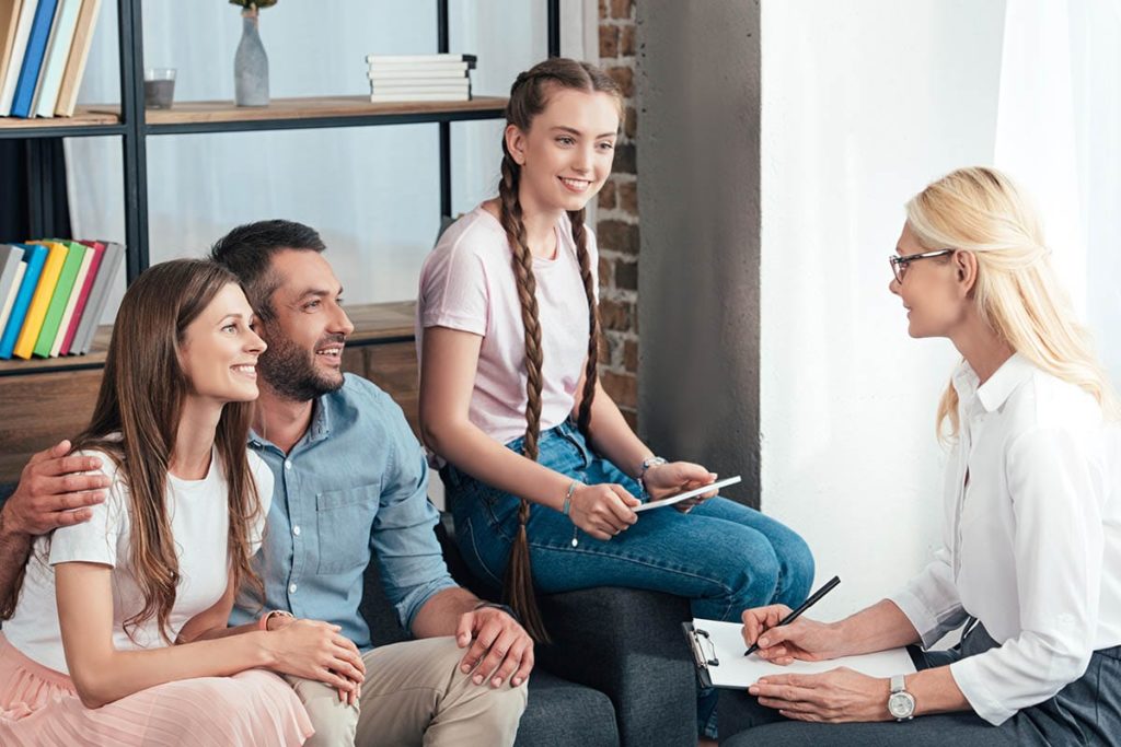 girl in braids and parents learning what is family therapy