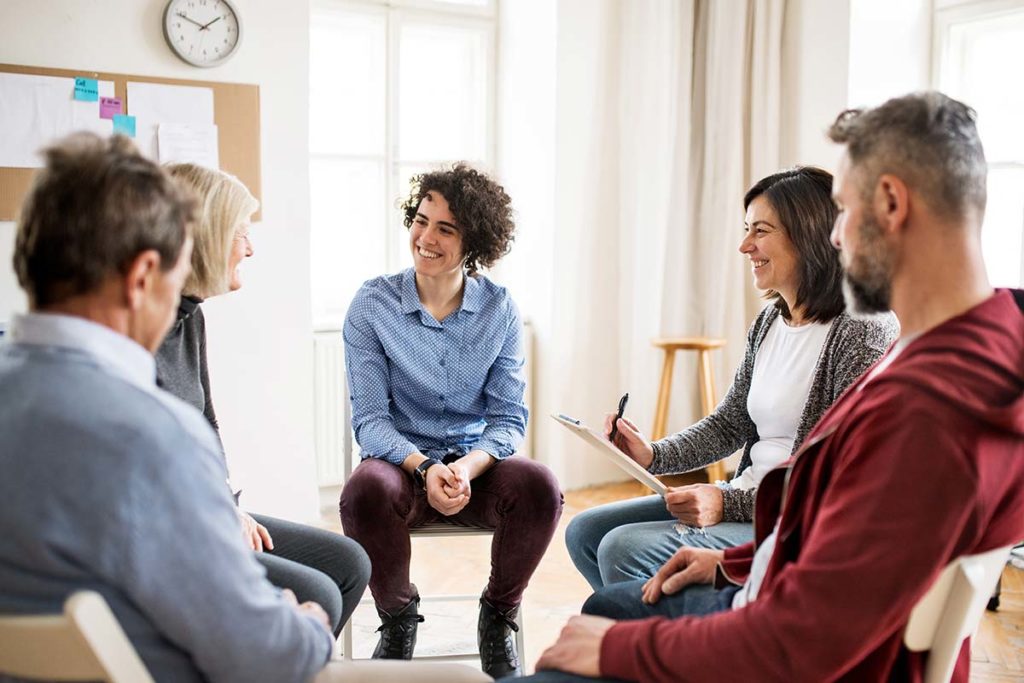 person in blue button down shirt participating in group therapy activities