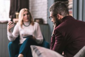 woman in sweater talking with man in maroon shirt about what is emdr therapy