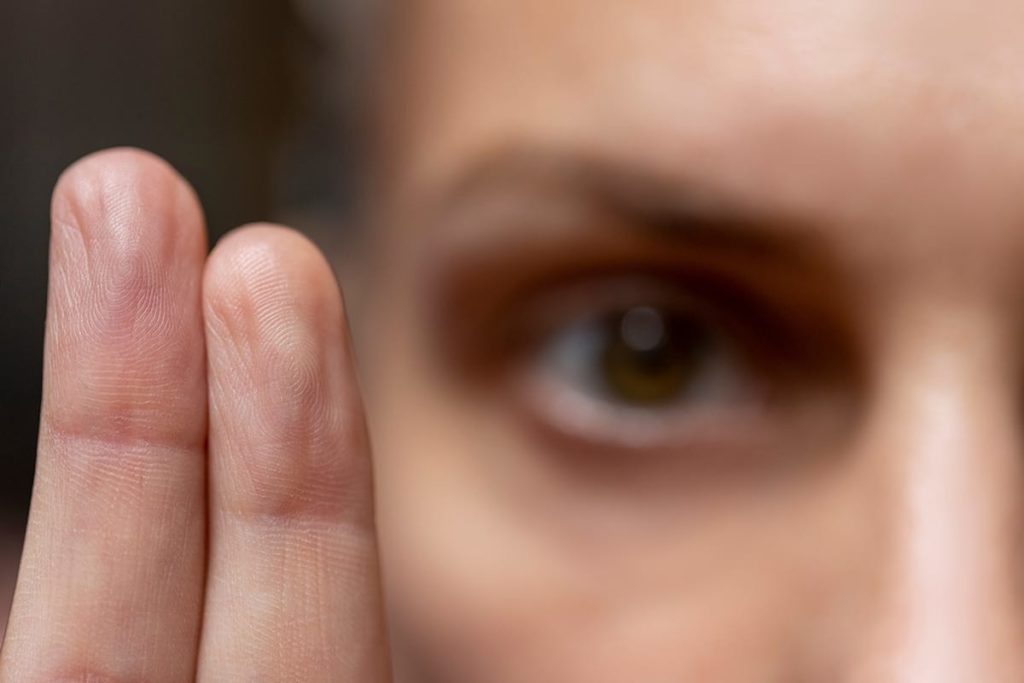 woman holding up two fingers while experiencing the benefits of emdr therapy for anxiety