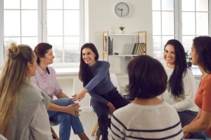 people smiling and learning about recovery through group therapy activities