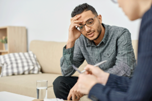 man with head in hand considers cognitive-behavioral therapy for anxiety