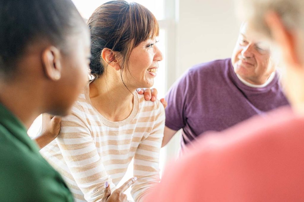 woman in striped shirt receives support while learning what is an intensive outpatient program