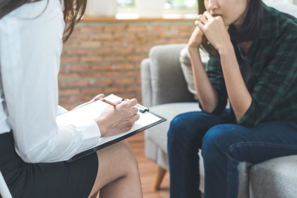 a therapist writes down notes while in a session with a client who asks what is relapse prevention therapy