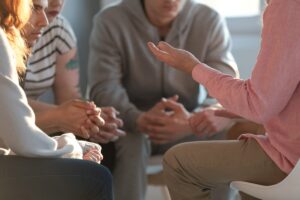 people in a group session discuss the stages of group therapy