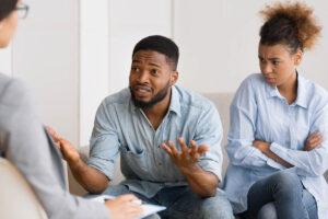 man talks with therapist about activities to improve mood while his wife looks on