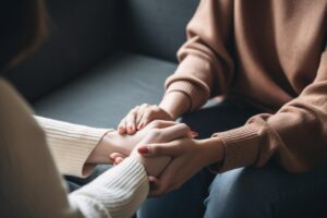 people clasp hands while discussing the signs your loved one has depression
