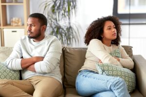 couple sitting on couch facing away from one another during an argument as an example of how weed ruins relationships